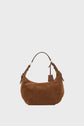 A brown suede sac hobo with a curved shape, crafted from luxurious cuir velours, features a short brown leather handle, gold hardware, and a small leather tag—embodying that effortlessly chic parisienne style against a plain white background.