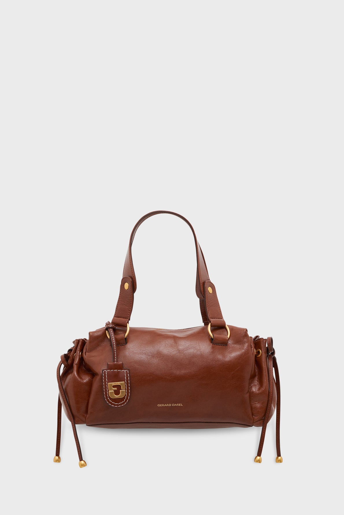 A brown cuir froissé leather handbag with two handles, gold hardware, drawstring sides, and a small tag. The bag boasts a smooth finish and BRUNO CAVALLI is printed in gold on the front, making this sac à main an elegant choice for everyday style.