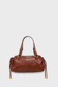 Brown leather sac à main with two short handles, gold hardware, and drawstring details on both sides, crafted in signature cuir froissé style by Maison Darel, set against a plain light gray background.