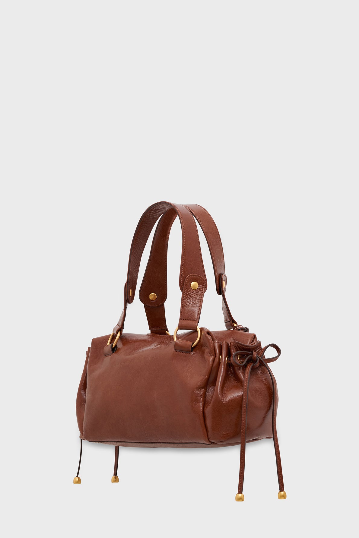 A brown cuir froissé leather sac à main with double handles, gold hardware, and drawstring details on the sides, displayed against a plain white background.