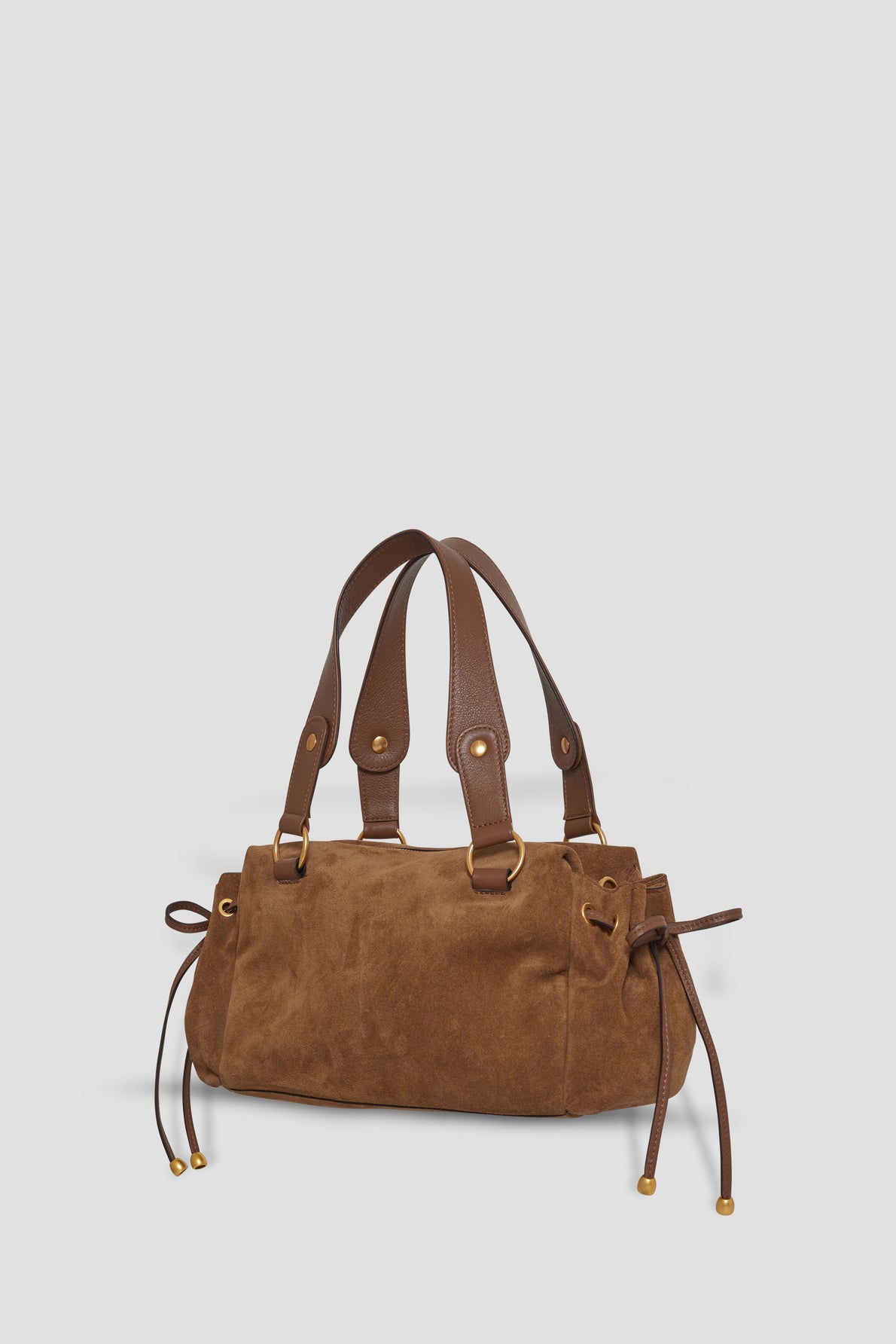 Brown cuir velours sac à main with dual leather handles, gold hardware, and decorative drawstring tassels on each side, featuring a fermeture zippée for added security, displayed against a plain white background.