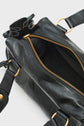 A close-up of a black sac à main in leather with gold hardware and a partially open zipper revealing the spacious interior, embodying chic à la française.