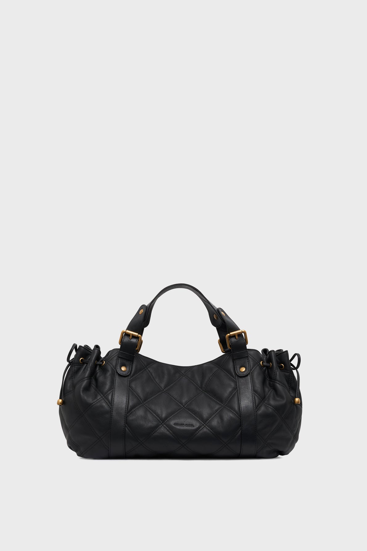 A black quilted leather sac à main with gold hardware, short handles, and drawstring details on the sides, displayed against a plain light gray background, showcases savoir-faire d’exception in its elegant version matelassée.