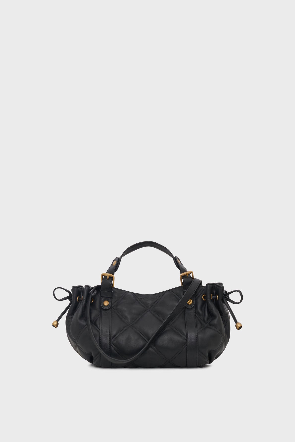 A black sac à main matelassé in quilted leather with gold hardware, featuring top handles, a bandoulière amovible for versatile styling, and side drawstring details, displayed on a plain light background.