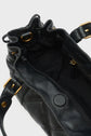 A close-up of an open black leather sac à main matelassé with gold hardware, showing the fabric-lined interior, a zippered pocket, and magnetic snap closure. The design features a bandoulière amovible for versatile carrying options, making this it-bag 24H both practical and stylish.