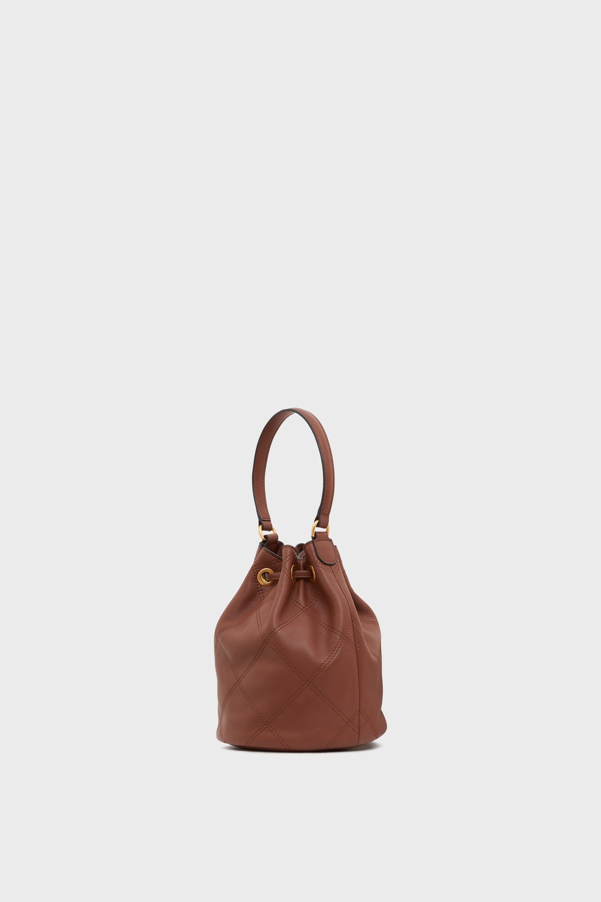 Brown leather bucket bag with a quilted pattern, gold hardware, and a single top handle, displayed against a plain light gray background—a stylish sac seau cuir that’s perfect for elevating your everyday look.