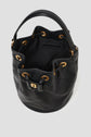 A black cuir de vachette leather bucket bag with gold eyelets and a drawstring closure, featuring a short handle, quilted stitching, and an open top showing the interior—a sophisticated sac seau perfect for everyday elegance.