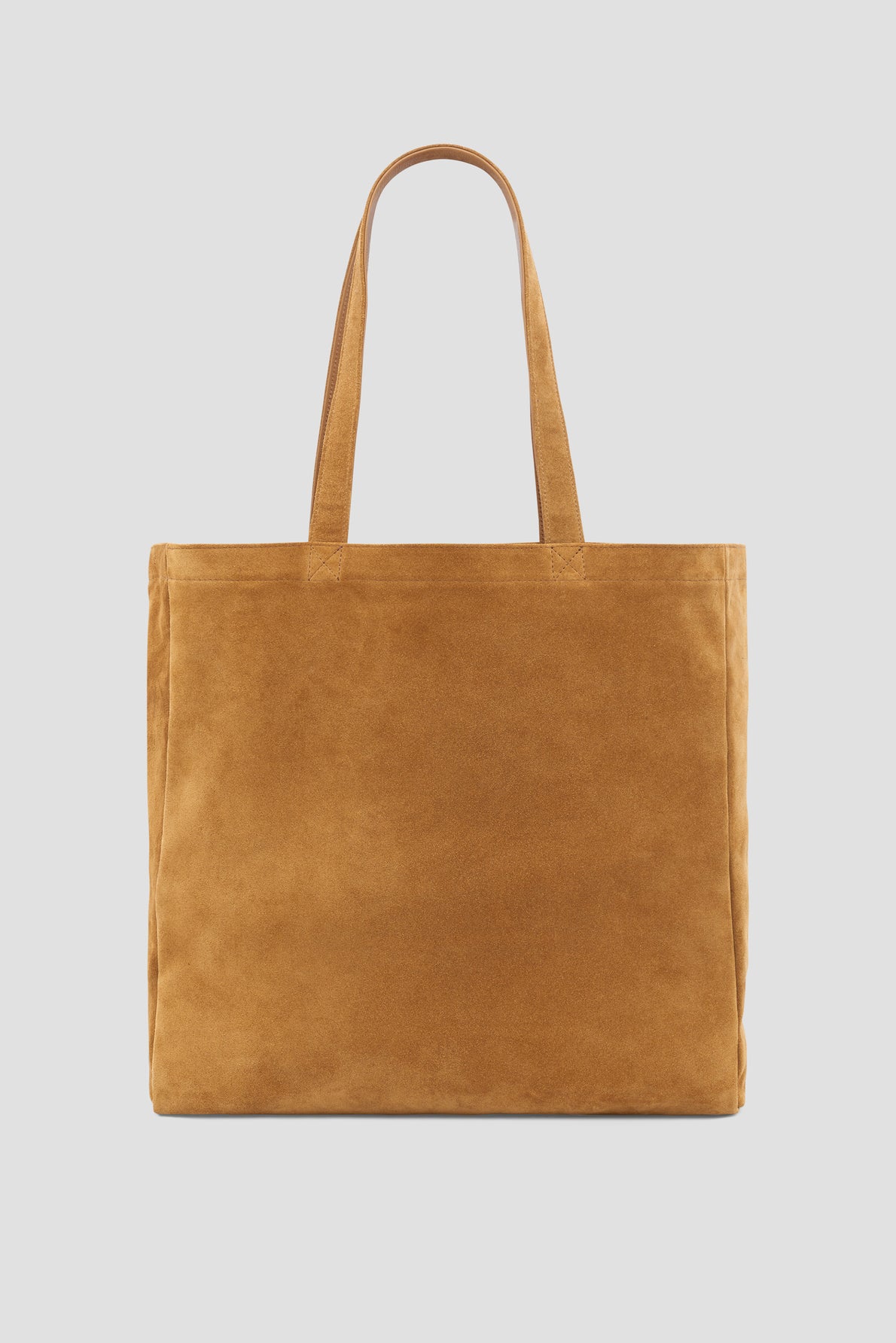 Tan suede tote bag with two handles, displayed on a plain white background. The bag has a simple, rectangular shape and a soft, textured appearance—reminiscent of timeless Merci Paris aesthetics. Perfect for everyday use, this tote bag cuir offers understated elegance and versatility.