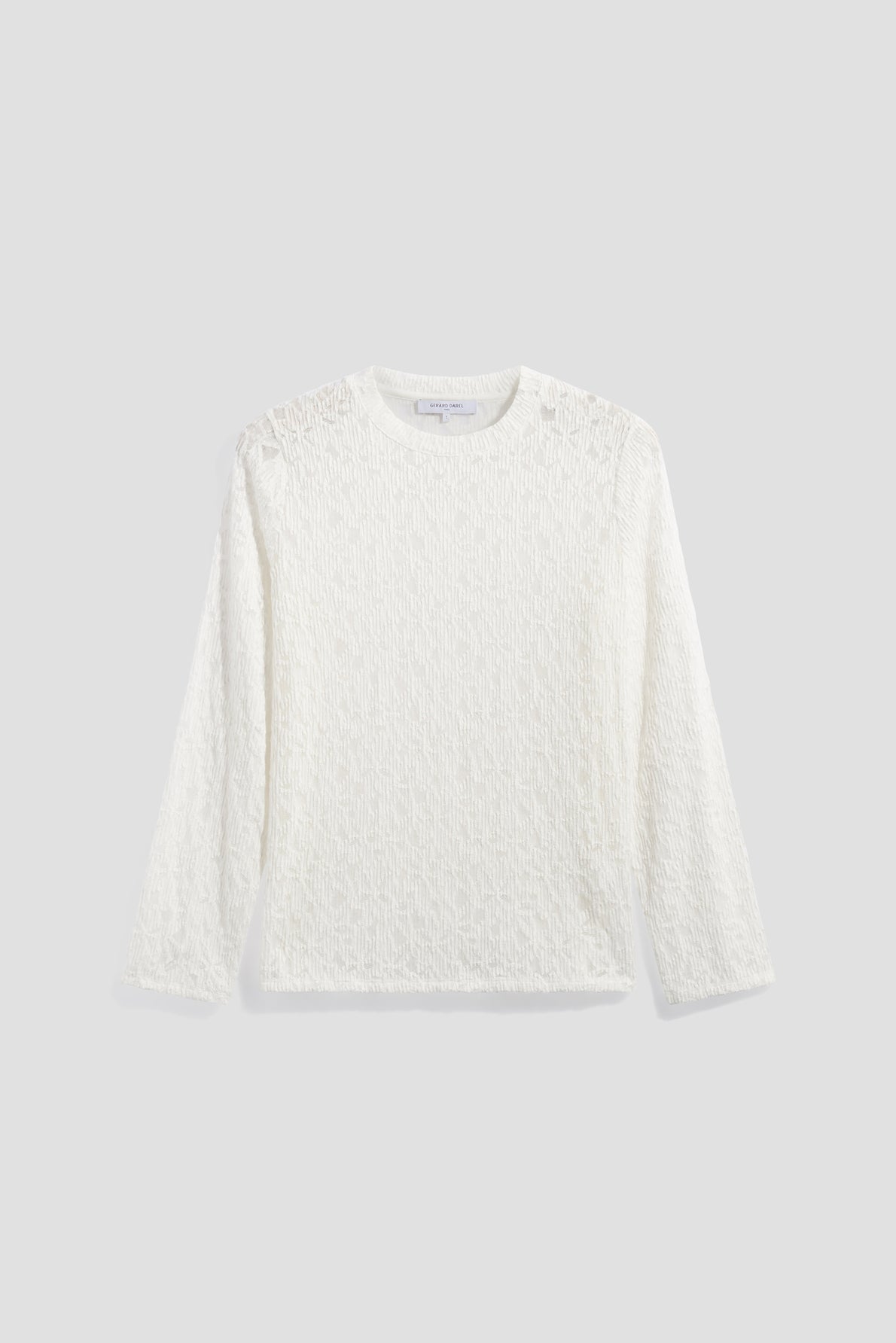 A long-sleeve, textured white shirt with a crew neckline, crafted from matière stretch and featuring subtle dentelle motifs floraux, displayed on a plain light gray background.