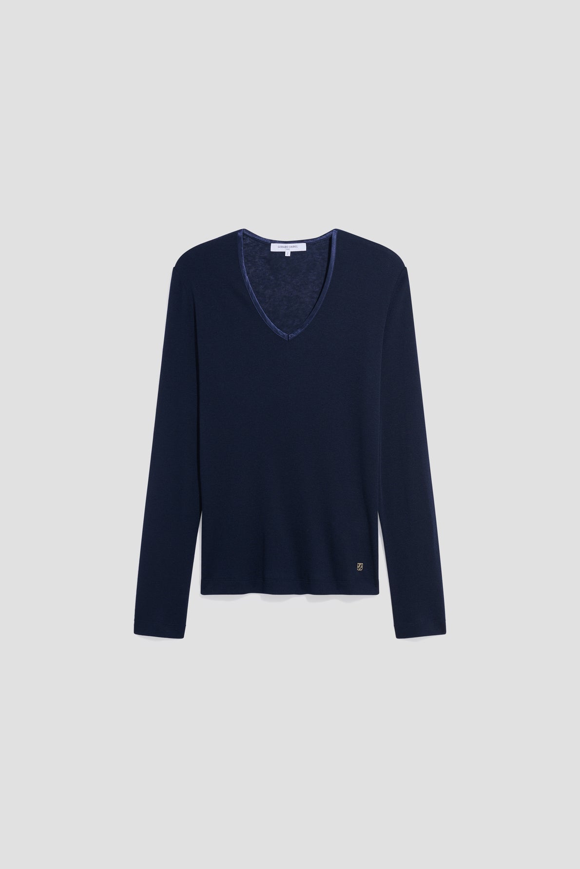 Navy blue V-neck long-sleeve sweater with a subtle logo tag near the hem, reminiscent of a classic tee-shirt col V femme, displayed on a plain light gray background.