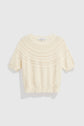 Short-sleeve cream pull en coton knit sweater with textured, decorative patterns and subtle motif ajouré around the yoke, shown on a plain white background.