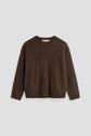 A brown, long-sleeved, fuzzy crew-neck sweater—reminiscent of a pull marron—is laid flat on a plain light gray background.