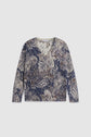 Long-sleeved pull col V with a dark blue background and an intricate imprimé cachemire in white and light brown shades. The fabric appears soft and lightweight.