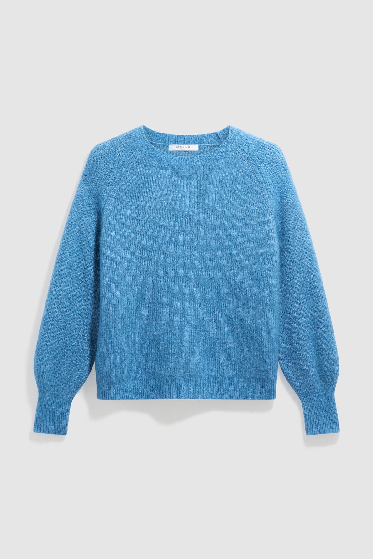 A blue, long-sleeve, crew-neck sweater made of a soft, ribbed knit fabric with a subtle pull bleu intense hue, displayed against a light gray background.