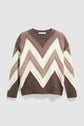 Brown and cream crewneck sweater with large zigzag chevron pattern in various shades of brown and beige. This pull à grands chevrons features long sleeves and a ribbed collar, hem, and cuffs for a cozy fit. Crafted in pull 100% laine, it’s perfect for adding a touch of graphic style to your winter wardrobe.