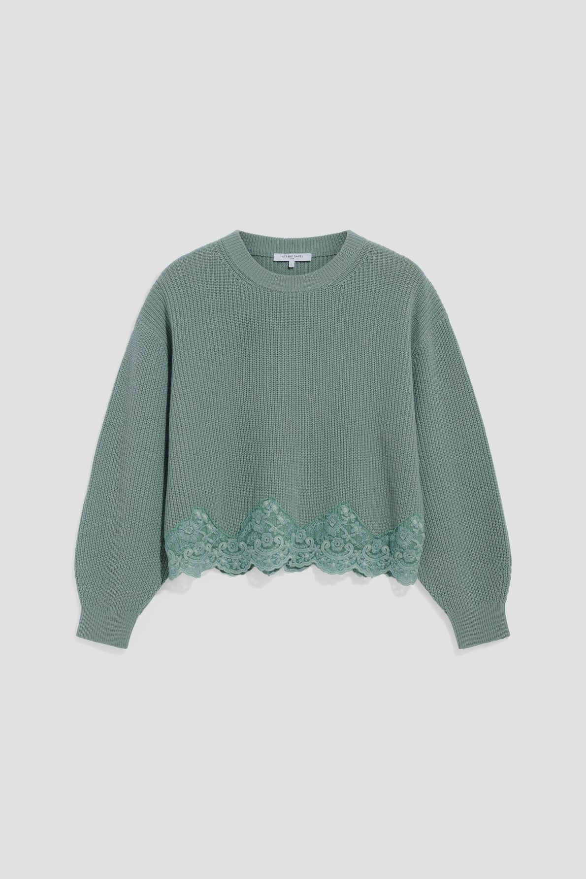 Green knit sweater with long sleeves, ribbed cuffs, and a round neckline. The hem features a scalloped lace trim with floral details, adding a touch of elegance to this pull dentelle. This cozy pull laine femme is displayed against a plain white background.