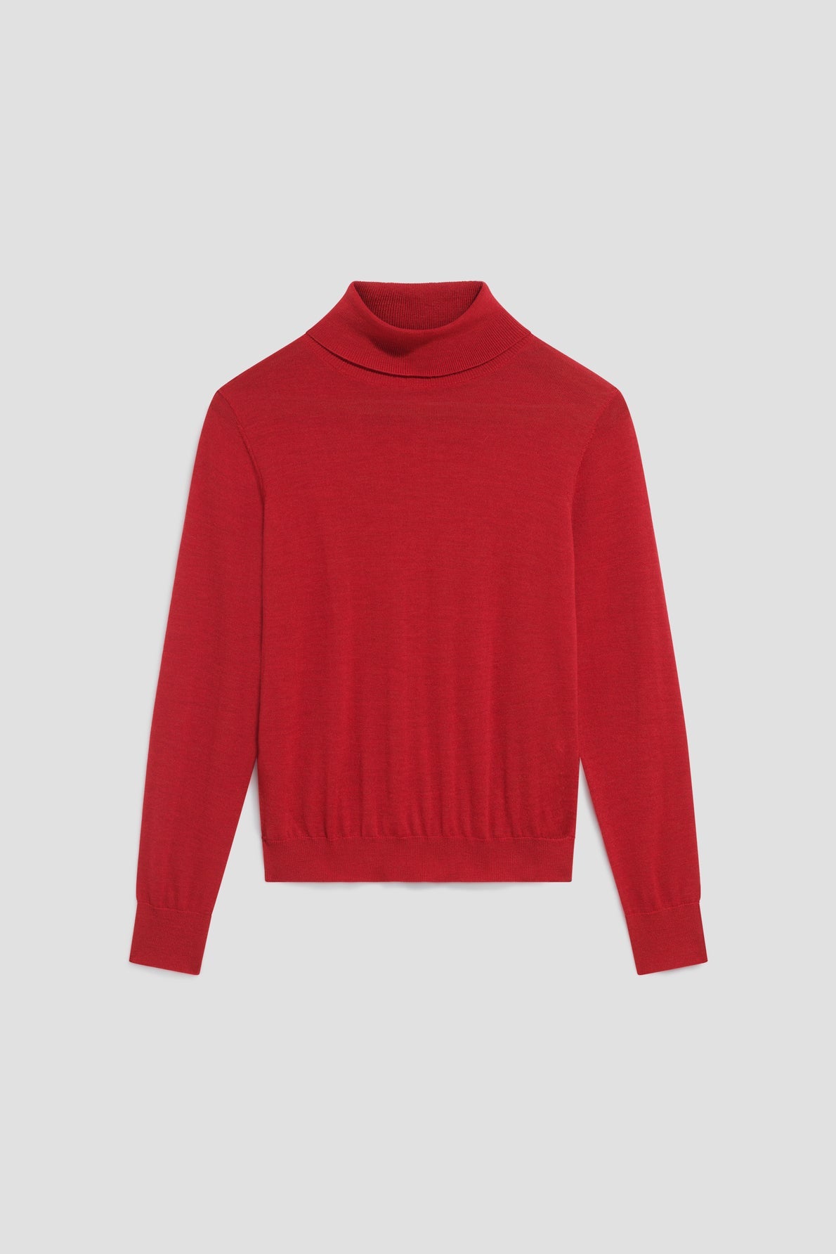A plain, long-sleeved pull col roulé rouge vibrant en laine mérinos is laid flat against a light gray background.