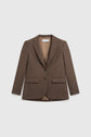 Brown tailored blazer with notched lapels, two front flap pockets, one chest pocket, and two buttons, displayed on a white background. This veste de tailleur features a classic cut in soft wool, offering timeless style for the modern woman.