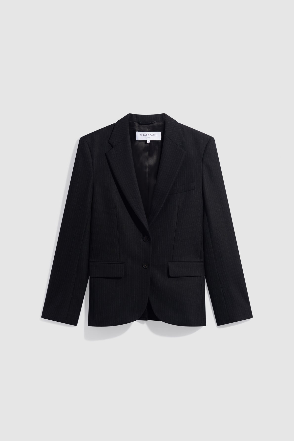 A black, tailored blazer with two buttons and a notched lapel, perfect as a veste bureau chic or veste tailleur noire, displayed against a plain light gray background.
