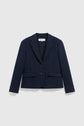 A navy blue veste tailleur femme with two front buttons, notched lapels, and two flap pockets, crafted from fine laine vierge and displayed on a plain light grey background.