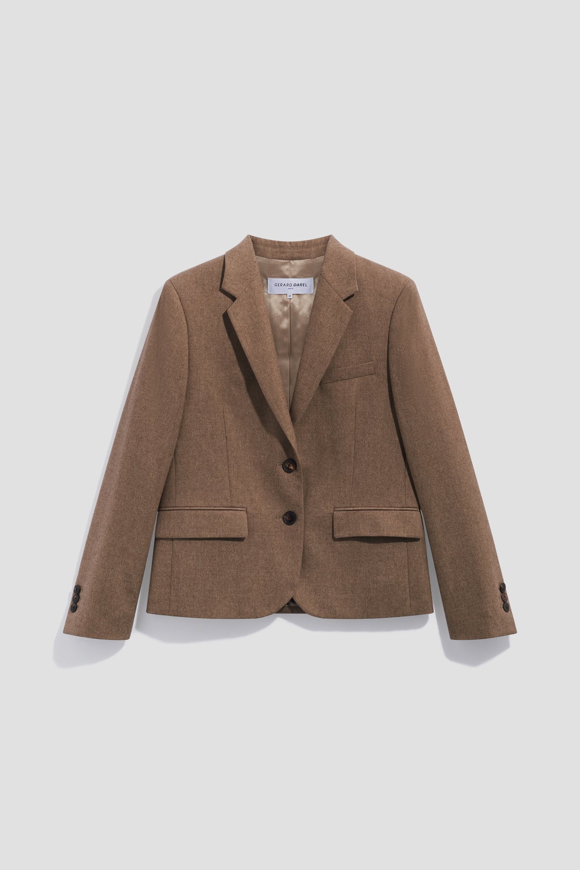 Brown tailored blazer with two buttons, notched lapels, front flap pockets, and a chest pocket, reminiscent of a classic veste de tailleur in flanelle beige, displayed against a plain white background.