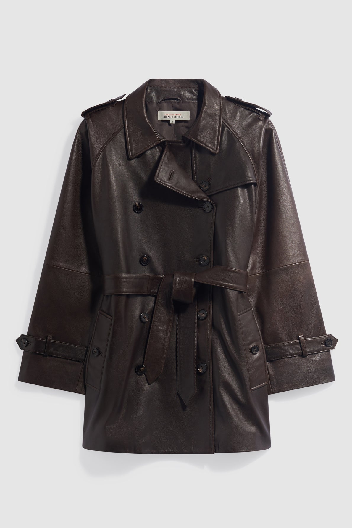 A dark brown cuir brillant leather trench coat with a belted waist, double-breasted buttons, shoulder epaulettes, and front pockets, displayed on a plain light background, perfect as a chic manteau femme for any stylish wardrobe.