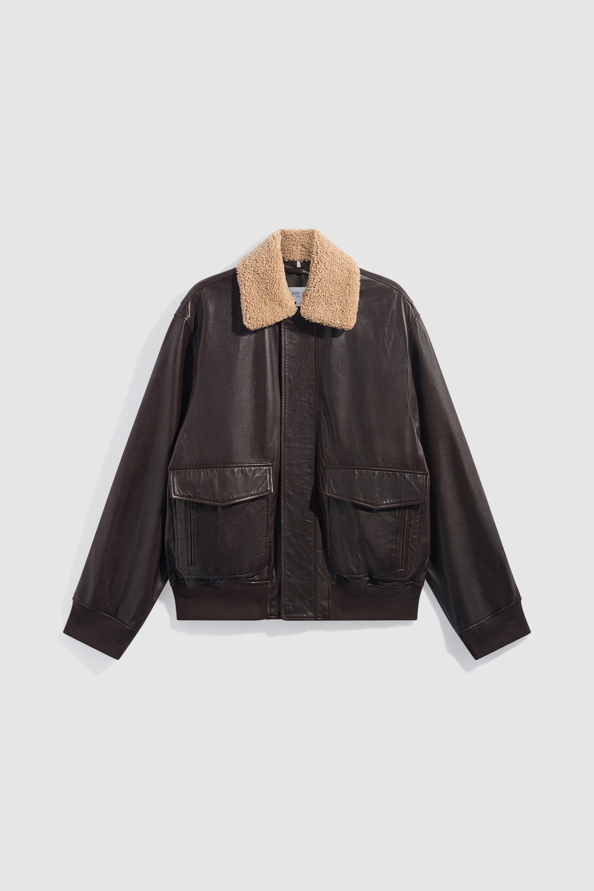 A dark brown blouson en cuir bomber jacket with large front pockets and a tan col mouton shearling collar, displayed on a plain white background.