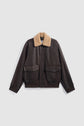 A dark brown blouson en cuir bomber jacket with large front pockets and a tan col mouton shearling collar, displayed on a plain white background.
