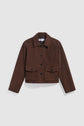 A brown suede jacket with a collar, button-down front, long sleeves, and two front flap pockets. This veste casual chic in cuir velours is laid flat on a plain white background.