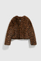 A cropped faux fur jacket with a brown and black imprimé léopard pattern, long sleeves, and no visible buttons, displayed on a plain light gray background. This manteau court adds bold style to any wardrobe.