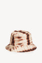 A chapeau en soie with an imprimé tie and dye pattern in beige, brown, and black tones, finished with a bord surpiqué, displayed on a plain white background.
