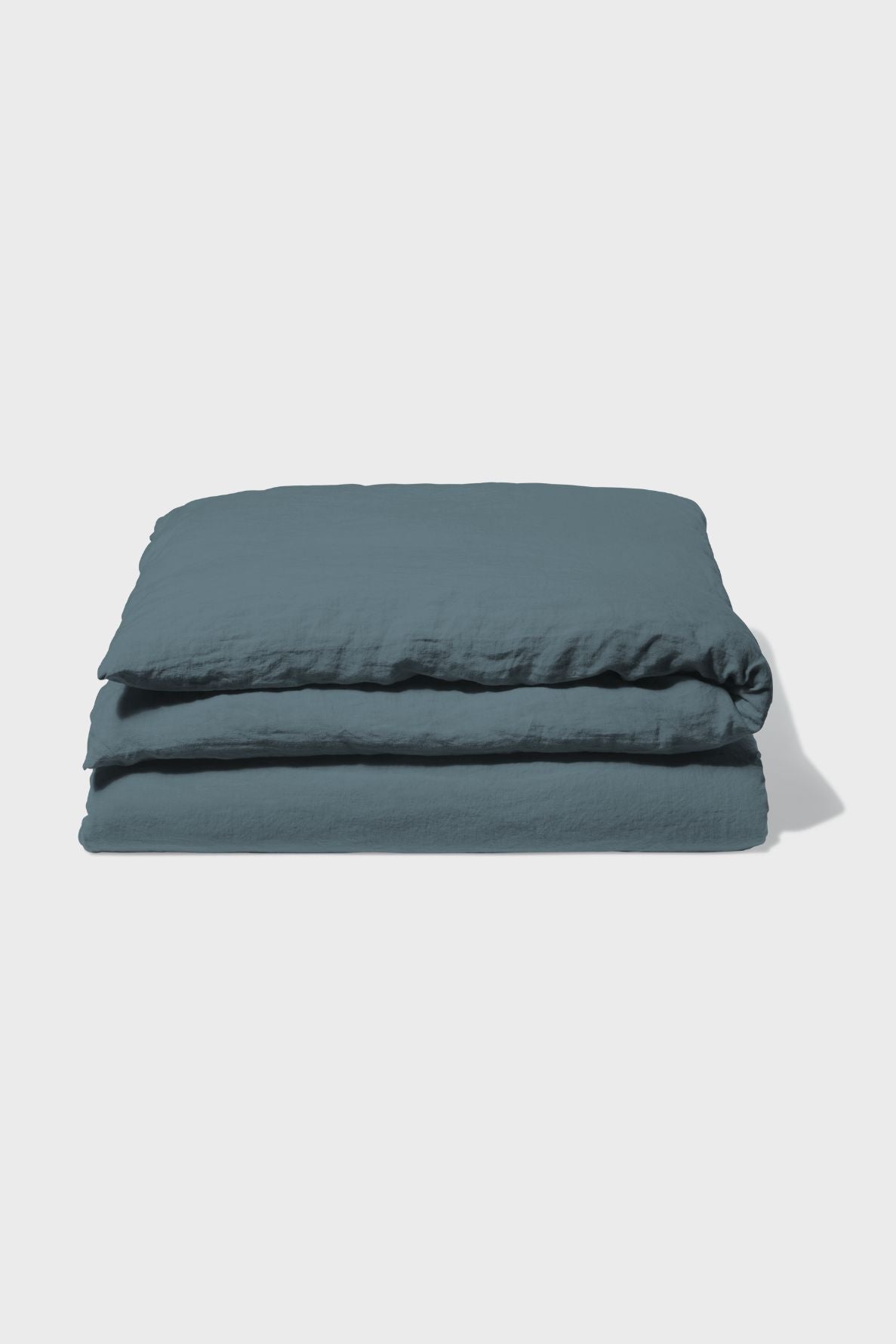 A neatly folded dark blue duvet cover is placed against a plain white background.