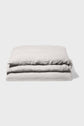 A neatly folded light gray blanket or duvet lies on a plain white background, showing its soft, textured fabric and clean edges.
