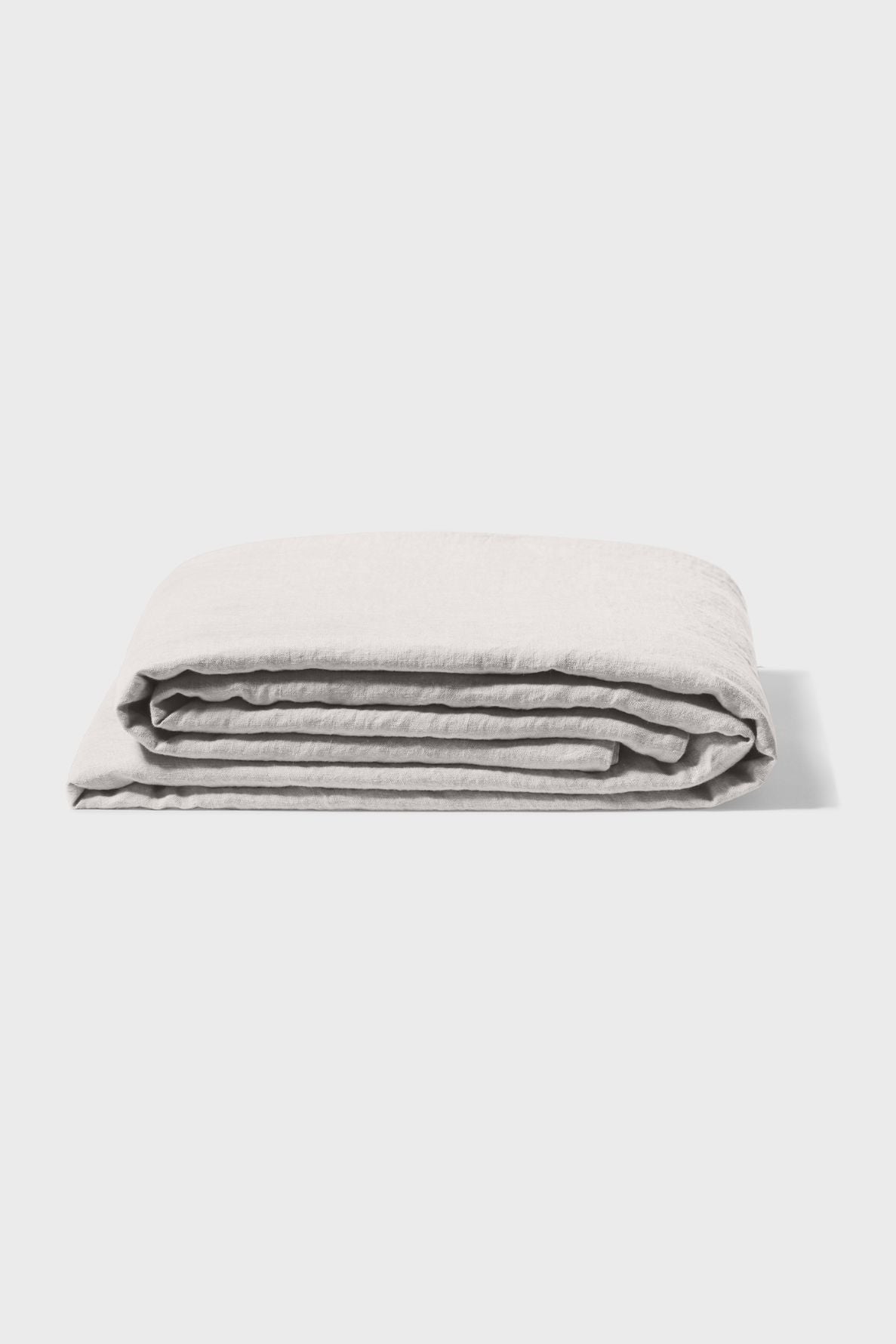 A neatly folded light gray bedsheet is displayed against a plain white background.
