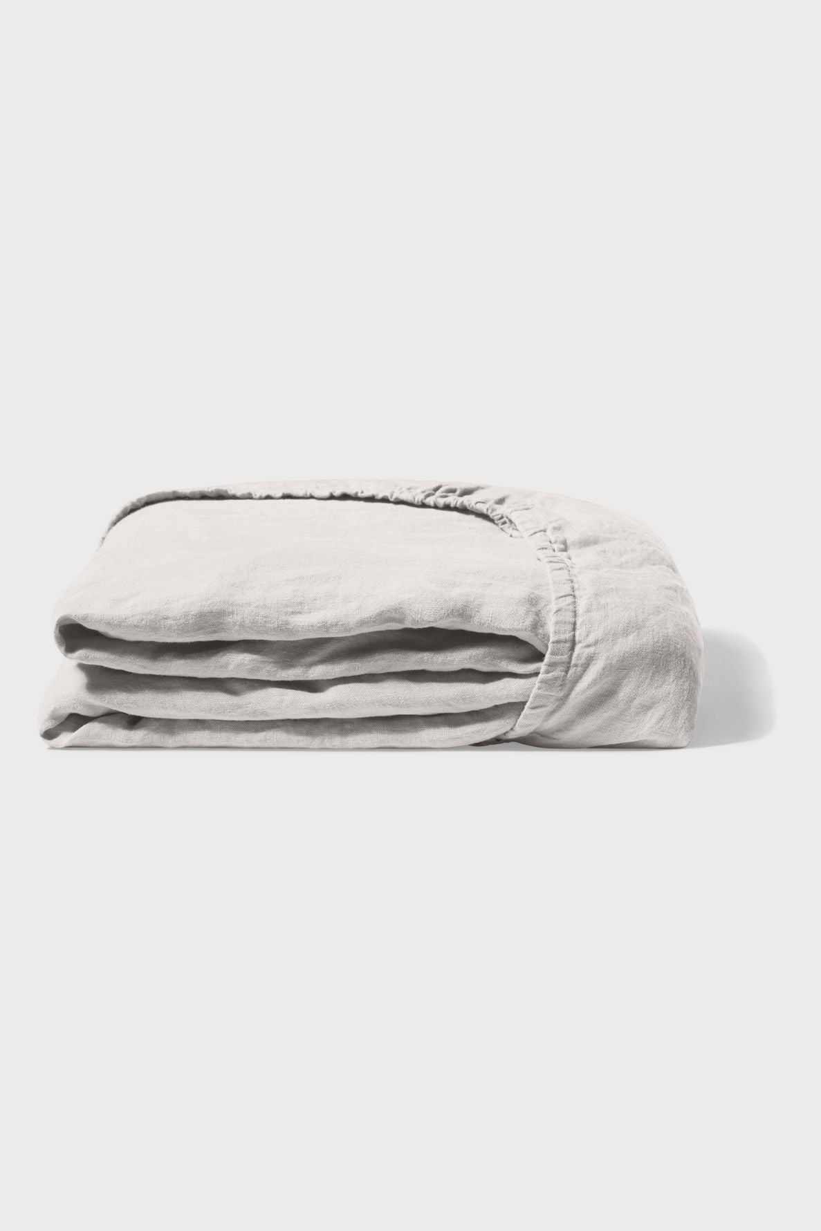 A neatly folded, light gray fitted bed sheet is shown against a plain white background.