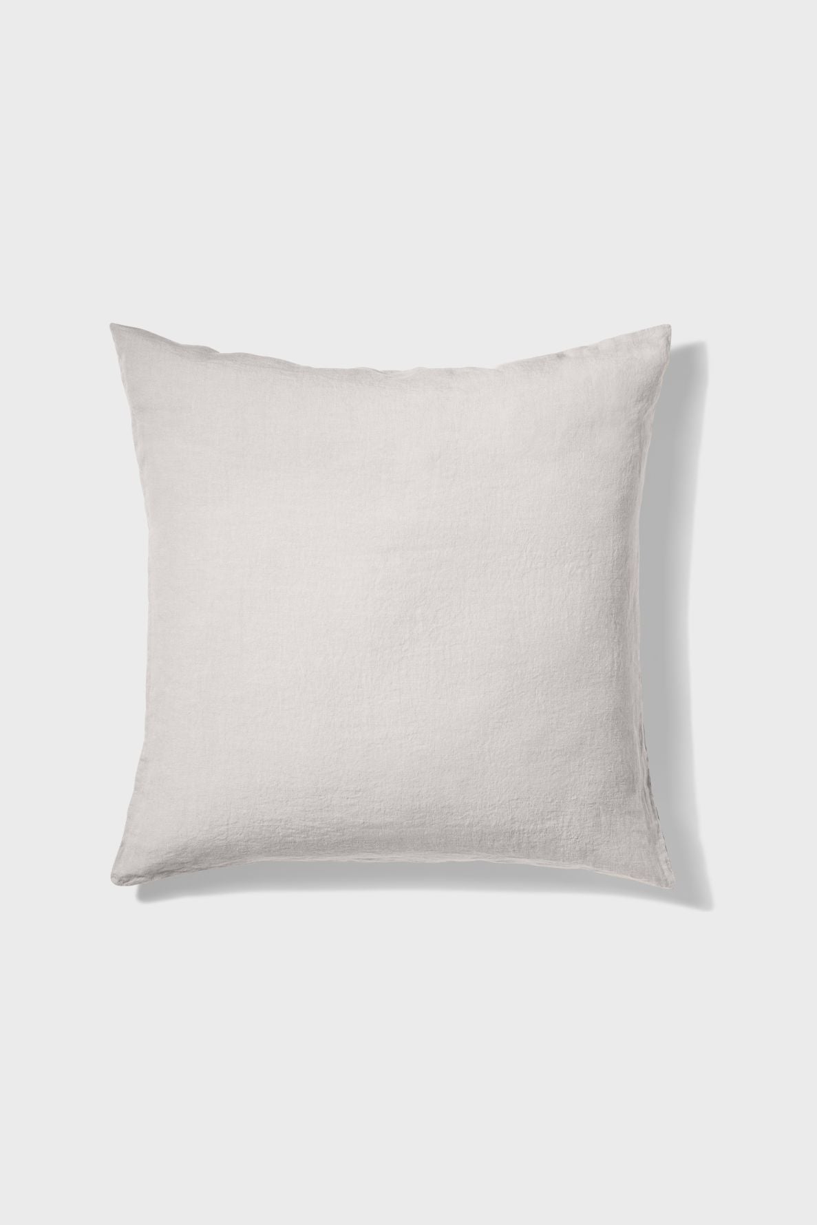 A square, light beige pillow with a subtle texture is shown against a plain white background.