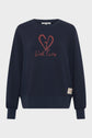 A navy blue sweatshirt with a red heart graphic and the words With Love on the front, featuring sérigraphie logo details, long sleeves, a relaxed coupe loose fit, and a small beige patch near the hem.