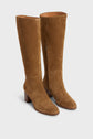 A pair of tall, tan bottes souples in cuir velours with mid-height talon carré block heels and almond-shaped toes, displayed against a plain white background.