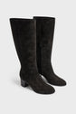 A pair of black bottes souples en cuir velours, knee-high with medium talon carré heels, side zippers, and rounded toes, displayed on a light gray background.
