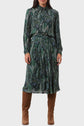 A person wears a long-sleeve, green paisley-patterned midi dress with a gathered waist and brown suede knee-high boots.