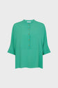 Green short-sleeve blouse with a mandarin collar, front button placket, and a loose, boxy fit—perfect as a blouse oversize for relaxed comfort. The blouse features subtle seam detailing on the chest and slightly flared sleeves.