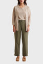 A person wearing a beige cardigan over a beige top, olive green wide-leg pants, and tan shoes, standing against a plain white background.