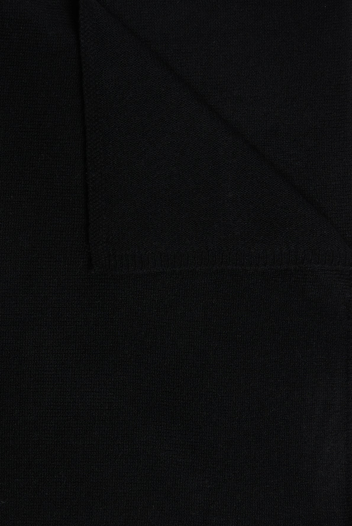 A close-up of a folded piece of black cachemire fabric with visible texture and stitching, capturing the sense of chaleur and comfort you’d expect from a luxurious écharpe.