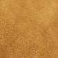 Close-up of a textured, golden-brown surface that appears to be sand or a granular material, reminiscent of the rich tones found in cuir velours on a sac iconique such as the sac à main Darel.