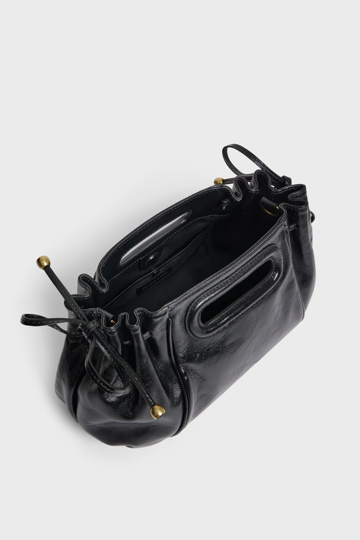 A black sac à main en cuir froissé with a ruched drawstring top, metal ball accents, and built-in handles, shown from above on a plain light background for an élégant touch.