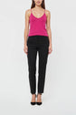 A person stands facing forward wearing a bright pink débardeur femme with fines bretelles, paired with black pants and black heels against a plain white background.