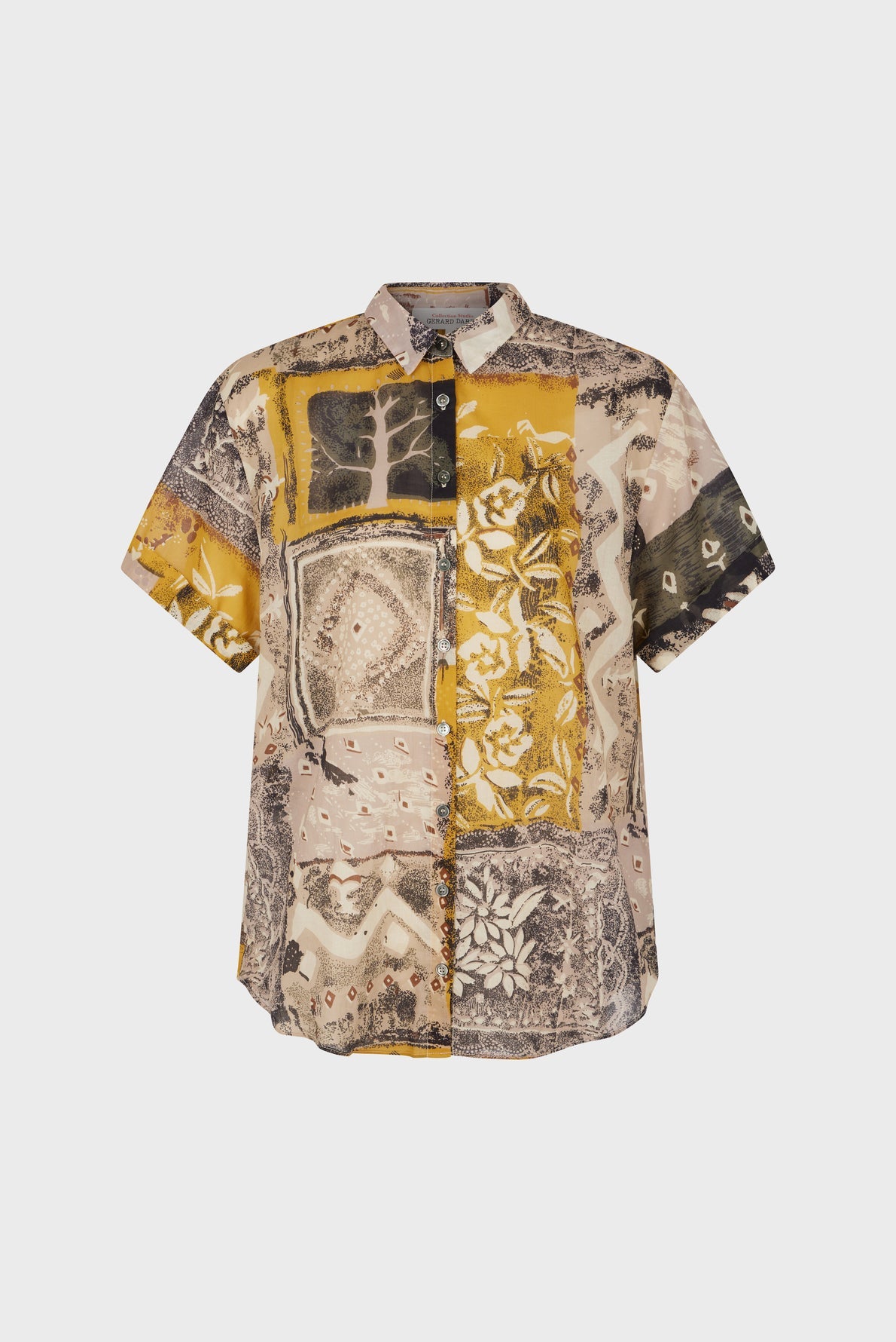 Short-sleeve button-up chemisette coton shirt with a patchwork design in mustard yellow, beige, and black tones, featuring various patterns including florals, geometric shapes, and an elegant imprimé africain—a standout piece from the collection Studio.
