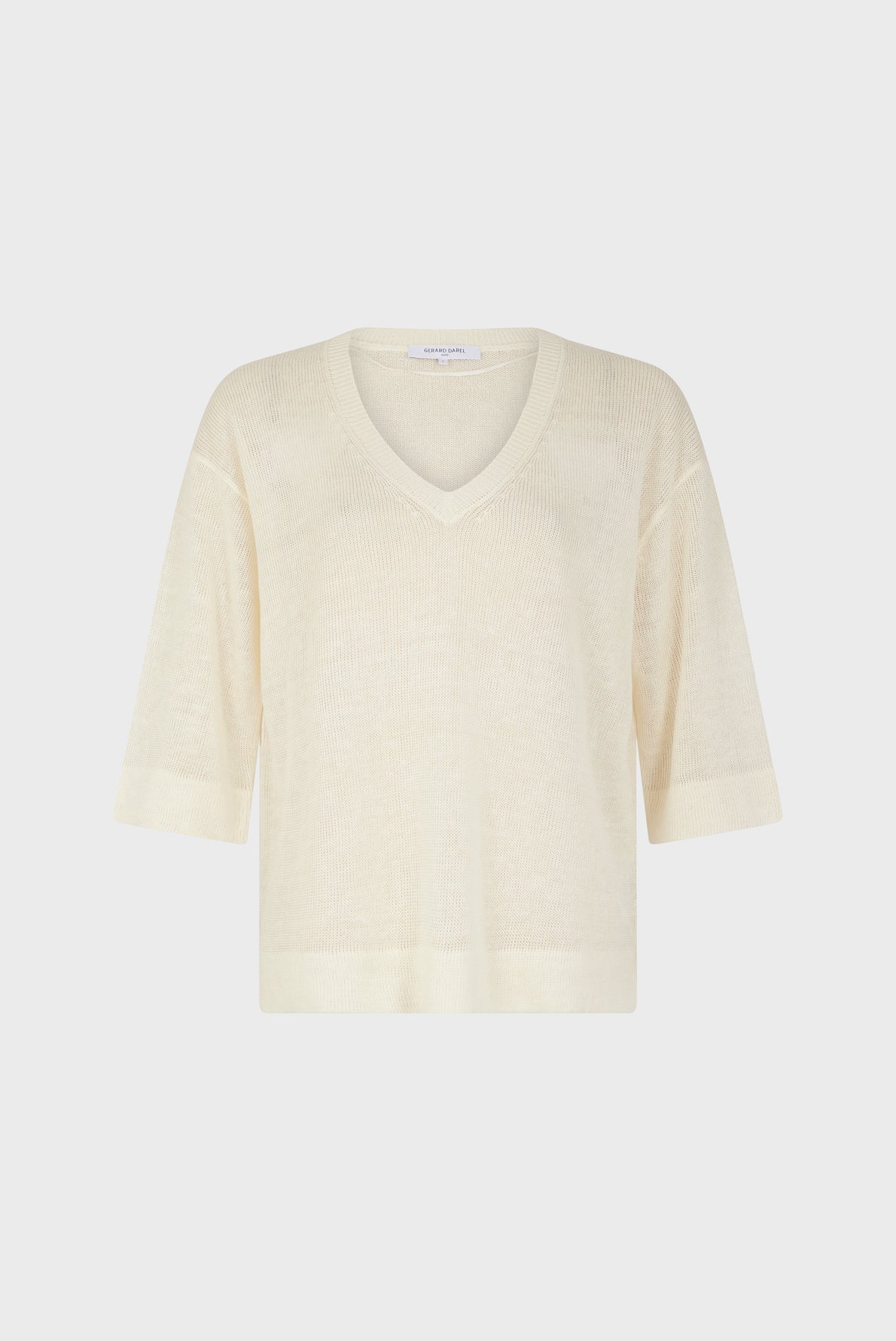 Cream-colored, short-sleeve knit sweater with a V-neck, shown on a plain white background. The sweater has a relaxed fit and ribbed hems on the sleeves and bottom.