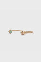 A gold open-ended bracelet laiton featuring a pierre turquoise stone on one end and an ornate lion head design on the other, displayed on a plain white background.