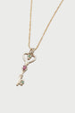 Gold necklace with a key-shaped pendant featuring a heart design and adorned with small pink and green gemstones, reminiscent of a sautoir clé. The elegant piece is displayed on a plain white background, highlighting its sophisticated style.